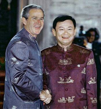 Thai Prime Minister Thaksin Shinawatra shakes hands with US President George W. Bush wearing their Thai silk summit jackets during a photo session of the APEC leaders, Bangkok, October 21, 2003.